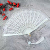 White lace fabric folding hand fan with red accents shown open and closed.