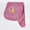 A soft, pink, fluffy hair towel embroidered with a rainbow star design.