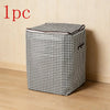 A single foldable clothing storage bag with a black and white houndstooth pattern resting on a wooden floor.
