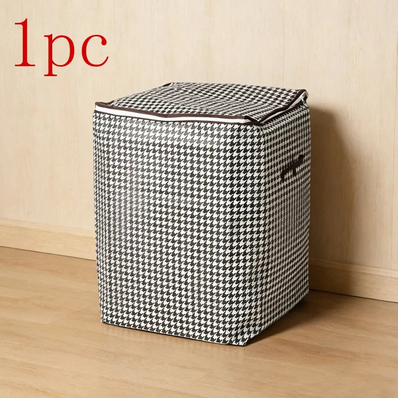 A single foldable clothing storage bag with a black and white houndstooth pattern resting on a wooden floor.
