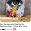 A painting of an eye created using numbers and colors on canvas with paint tubes and brushes nearby.