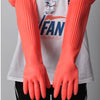 A pair of bright orange silicone dishwashing gloves worn on the hands against a white shirt.