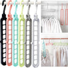 A set of collapsible rotating clothes hangers in various pastel colors hanging on a white rack.