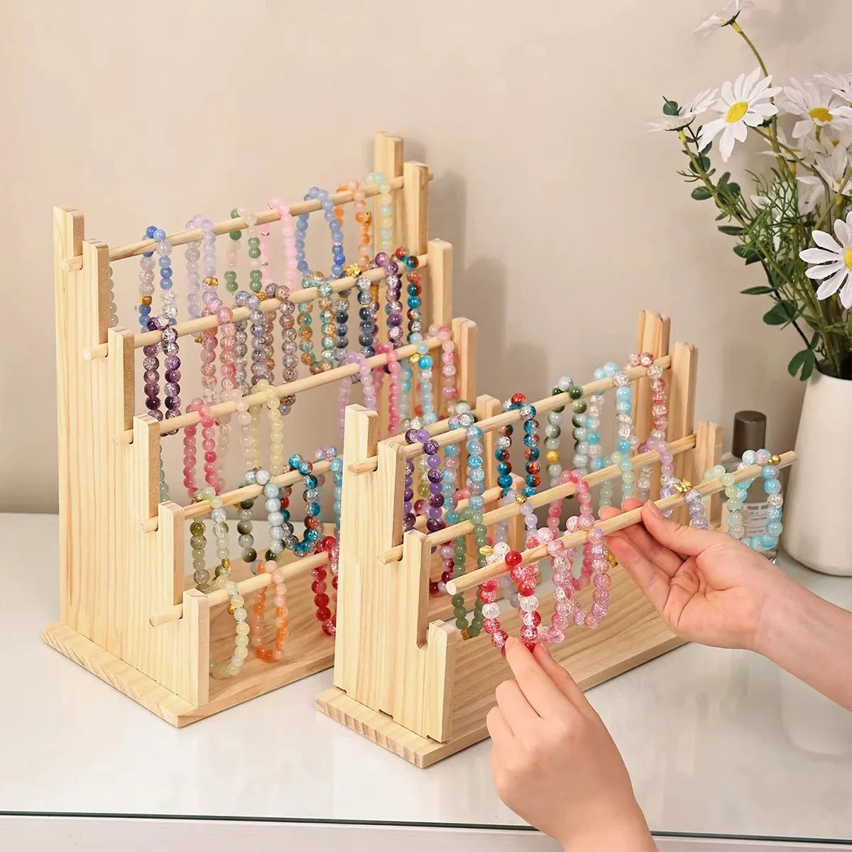 Solid wood ladder jewelry organizer displaying various colored beaded necklaces on multiple tiers