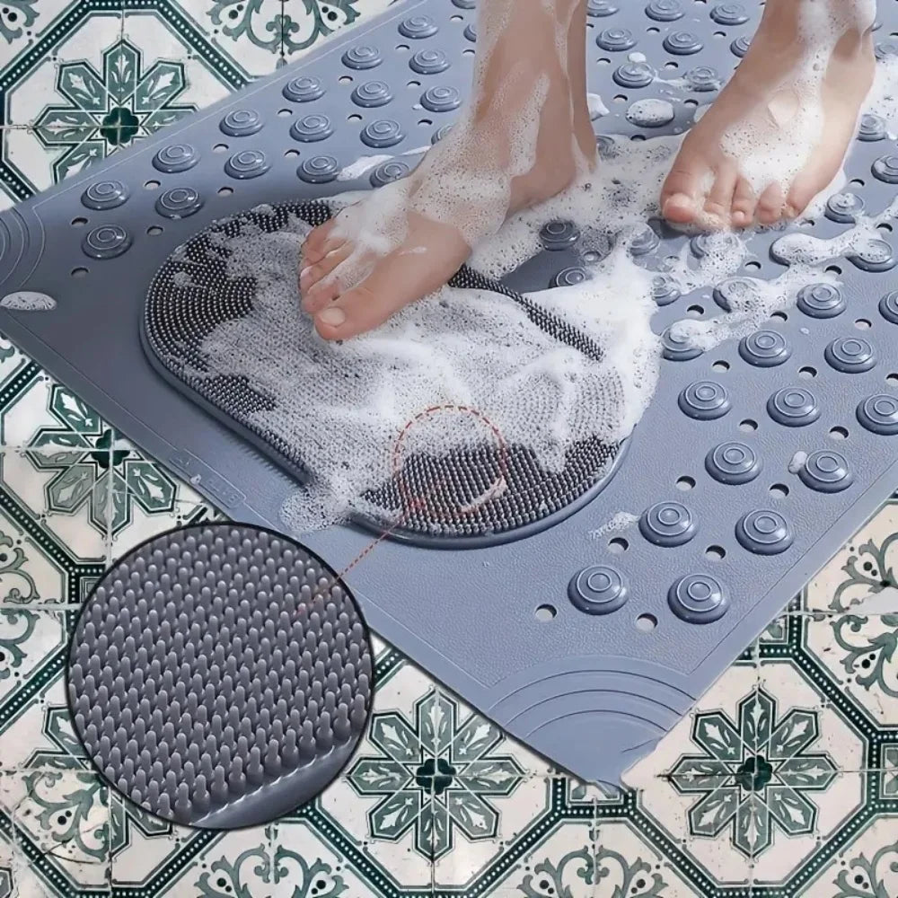 Los pies de una persona se remojan en una estera de masaje gris antideslizante sobre un suelo de azulejos estampados.