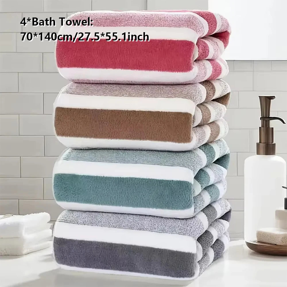 Ein Stapel von vier gefalteten Badetüchern in verschiedenen Farben, darunter rosa, beige, türkis und grau.