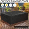 Housse imperméable noire pour mobilier de jardin protégeant une table en bois à l'extérieur.