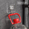 A red rotating wall hook is attached to a clear adhesive mount on a gray textured wall.