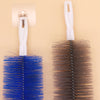A white bendable fan brush with a dark brown bristles is shown next to its holder.