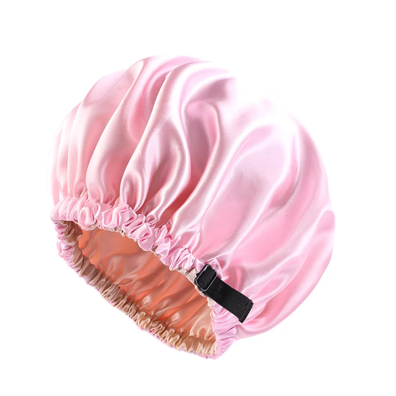 Pink satin sleep cap with a gathered edge and a black tie for curly hair