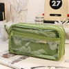A light green transparent pencil pouch resting on a white surface next to various stationery items.
