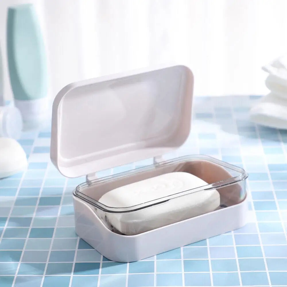 A white transparent drainage soap dish holding a bar of white soap on a blue checkered surface.