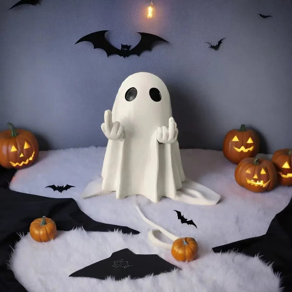 A white ghost figurine with outstretched hands sits on a white fluffy surface against a gray wall decorated with bats and pum