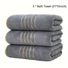 Three gray bath towels measuring 27 by 55 inches stacked neatly.