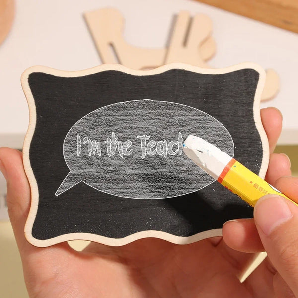 A hand holds a mini wooden chalkboard sign with a speech bubble drawn on it using white chalk.