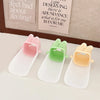 Three anti-splash faucet extenders in pink, green, and yellow with cute rabbit designs displayed on a white surface.