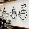 Un juego de tazas de café de hierro negro para decoración de pared, colgadas sobre una máquina de café.