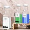 Three refillable glass bottles of laundry detergent with white caps and green and blue liquid inside