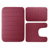 A set of three rectangular memory foam bathroom rugs in a dusty rose color.