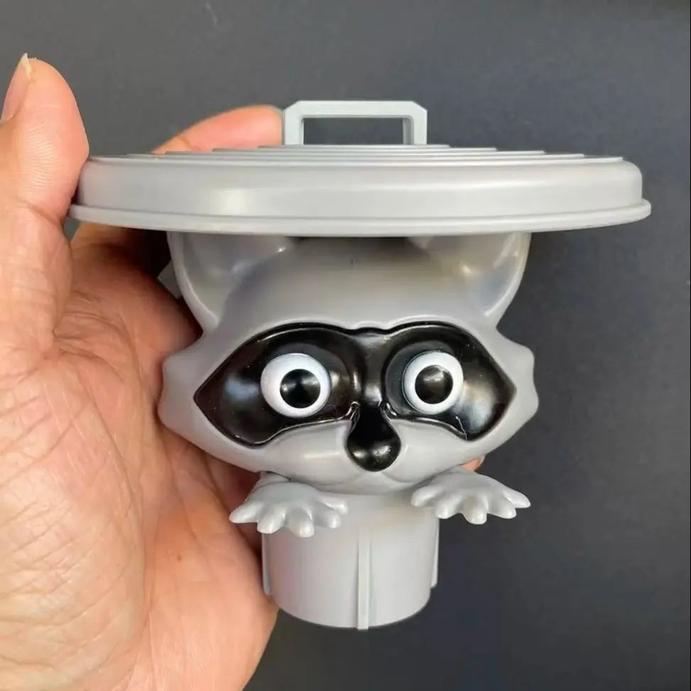 A gray decorative toilet paper holder shaped like an owl with large black eyes and a lid.