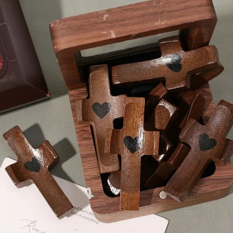 Un petit ornement de croix en bois est exposé dans une boîte en bois.