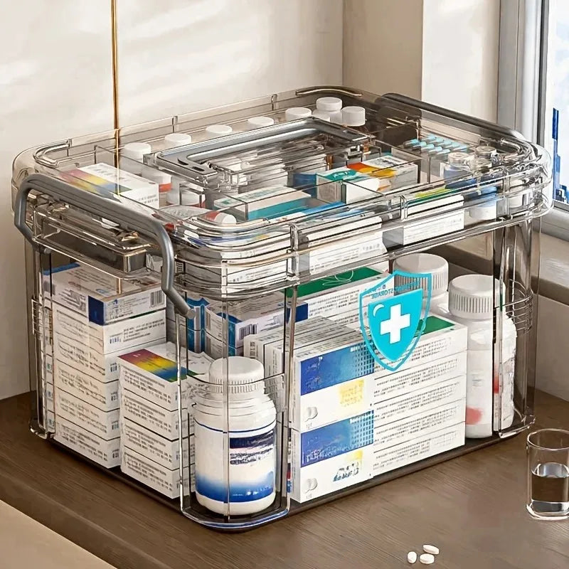 Transparente Plastik-Erste-Hilfe-Box mit Griff, gefüllt mit verschiedenen medizinischen Hilfsmitteln und Fläschchen.
