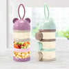 A layered silicone food storage box with purple and mint green components for baby snacks.