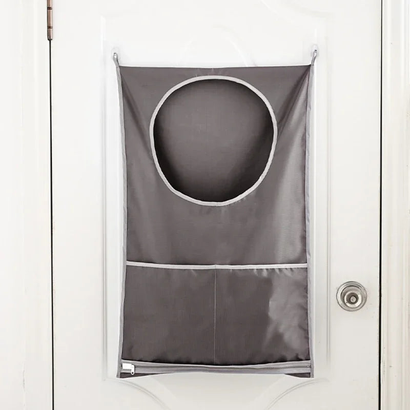 A gray fabric laundry basket organizer hanging on a white door.