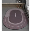 A round, multi-toned anti-slip floor mat with concentric rings and the word HOME printed on it, placed on a gray tiled floor.