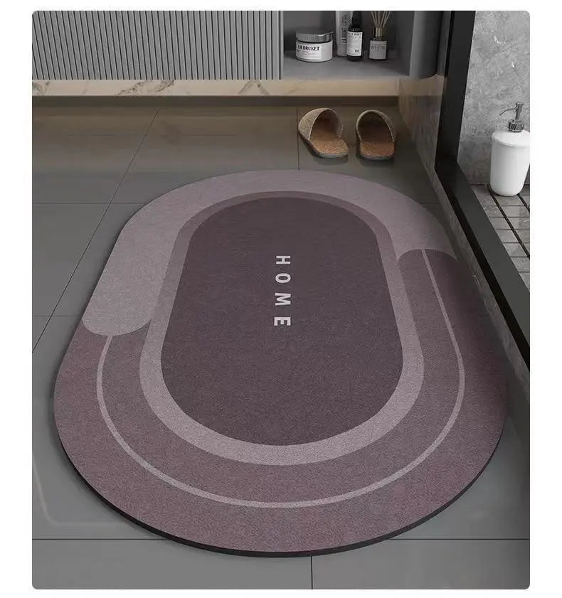 A round, multi-toned anti-slip floor mat with concentric rings and the word HOME printed on it, placed on a gray tiled floor.