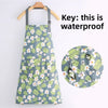 A light blue floral print kitchen apron hanging on a wooden hanger, demonstrating its waterproof feature.
