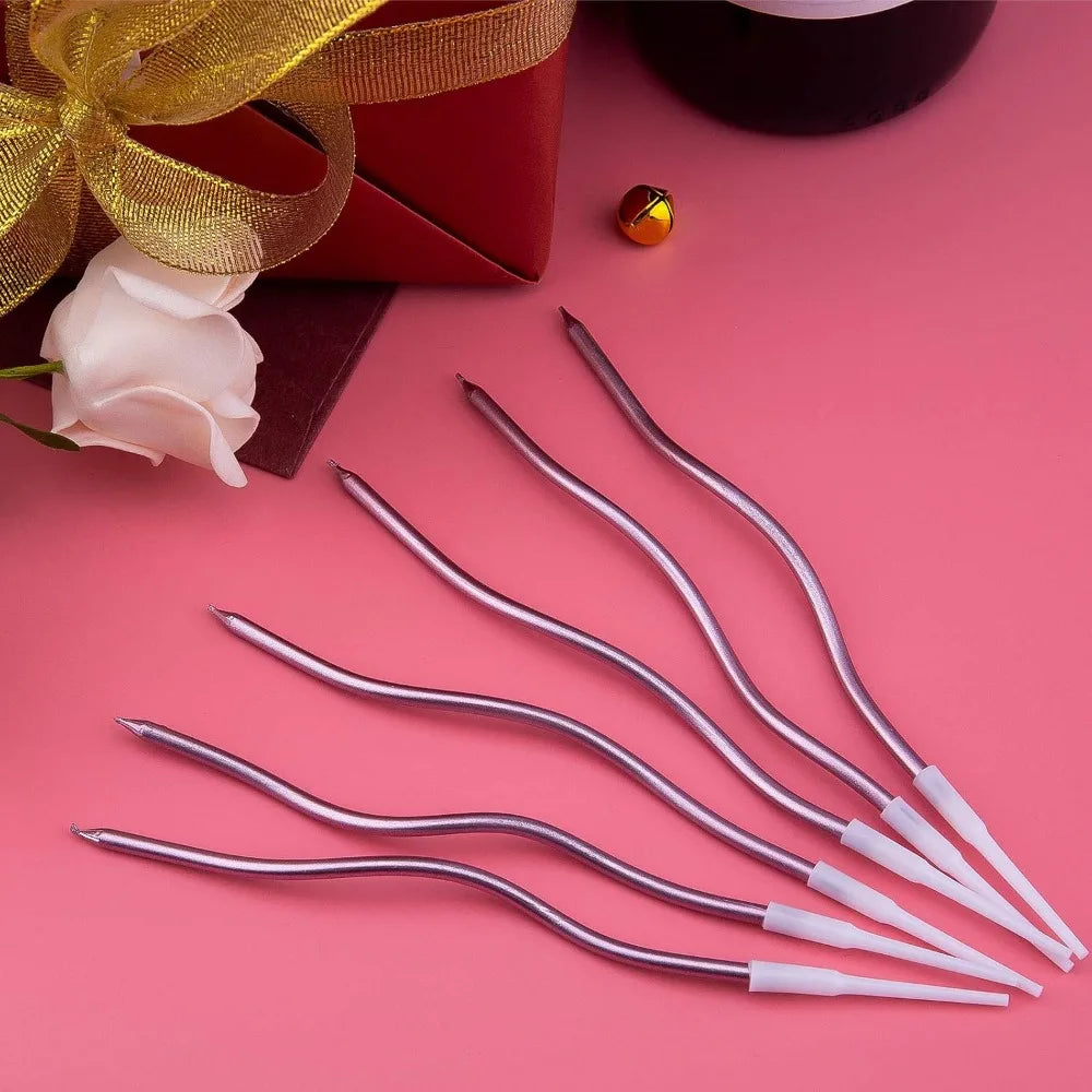 Ein Set dekorativer Spiral-Geburtstagskerzen in Silber und Weiß auf rosa Hintergrund.
