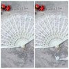White lace fabric folding hand fan with red accents shown next to a measuring tape.