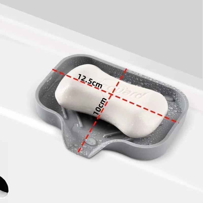 A white cylindrical item is placed in a gray silicone sink mat organizer with measurement lines.