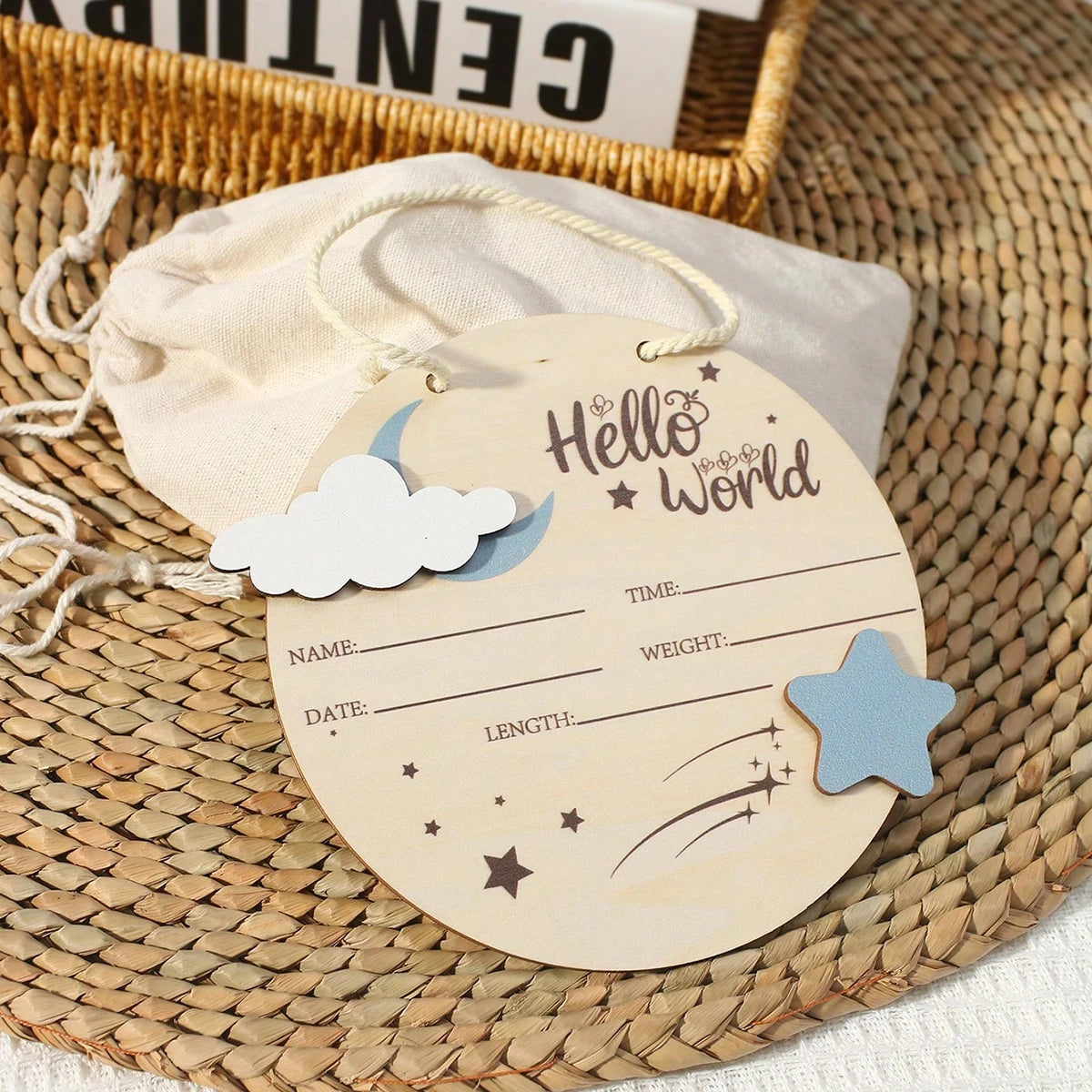 Etiqueta de madera con forma de luna creciente y estrellas, con el texto Hello World y campos para nombre, fecha y peso