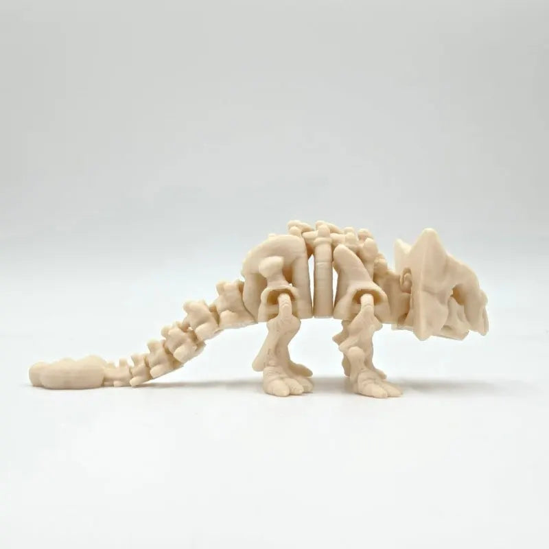 A light beige 3D printed dinosaur skeleton figure showing the spine and skull structure.