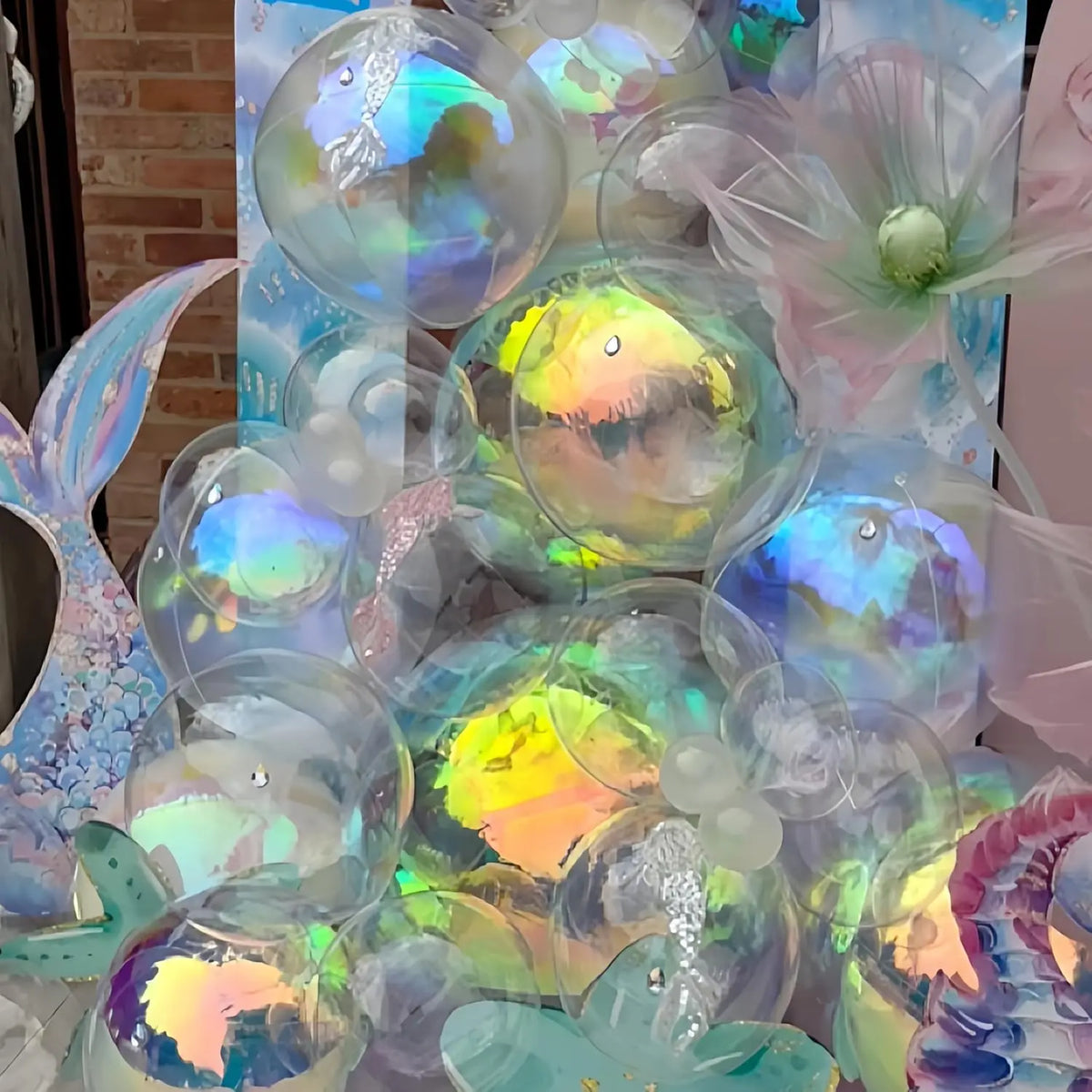 Eine Sammlung irisierender holografischer Partyballons in verschiedenen Farben und Größen.
