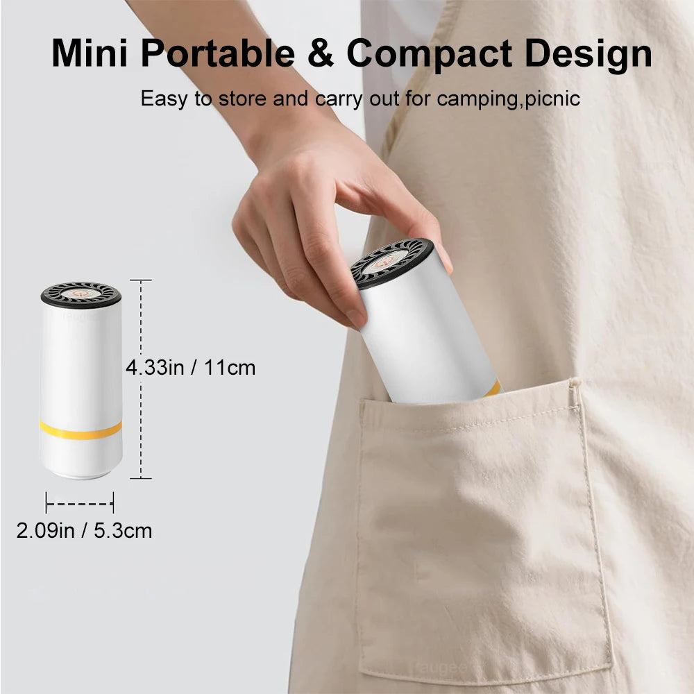 Une main tient une pompe électrique cylindrique blanche pour sacs de conservation alimentaires contre un tissu clair.