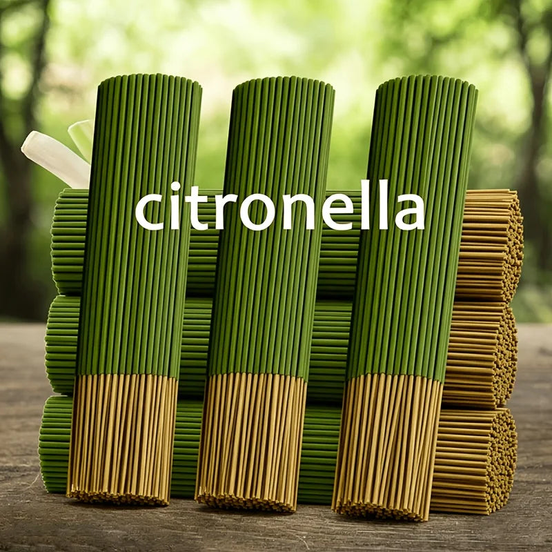 Green citronella oil sticks standing upright in a row on a wooden surface.