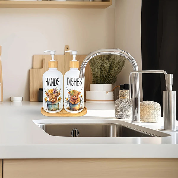 A set of white soap dispensers with cow motifs are displayed next to a kitchen sink and greenery.