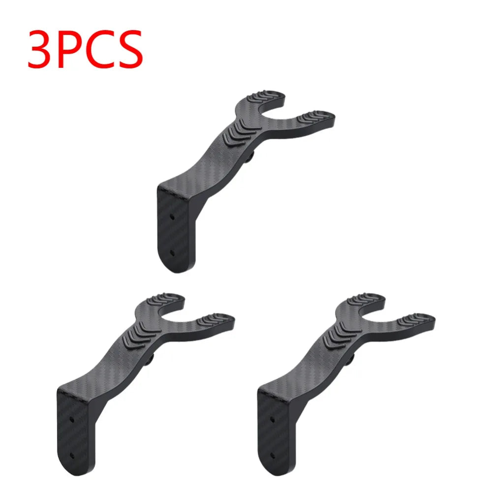 Three black versatile multi-use wall hooks designed for organization.