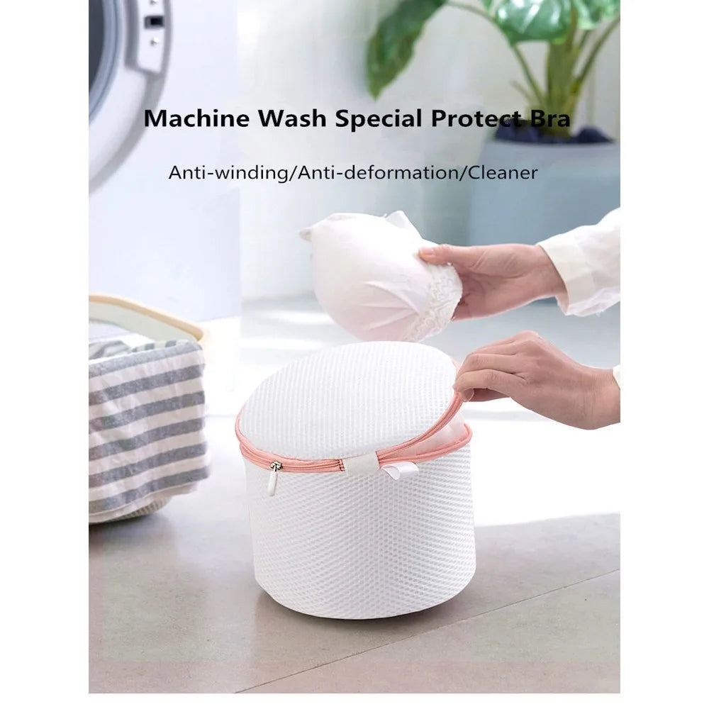 A hand is placing a white reusable laundry bag onto a white cylindrical storage container.