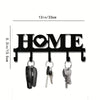 Black rustic iron key holder wall art with a heart cutout displaying the word HOME
