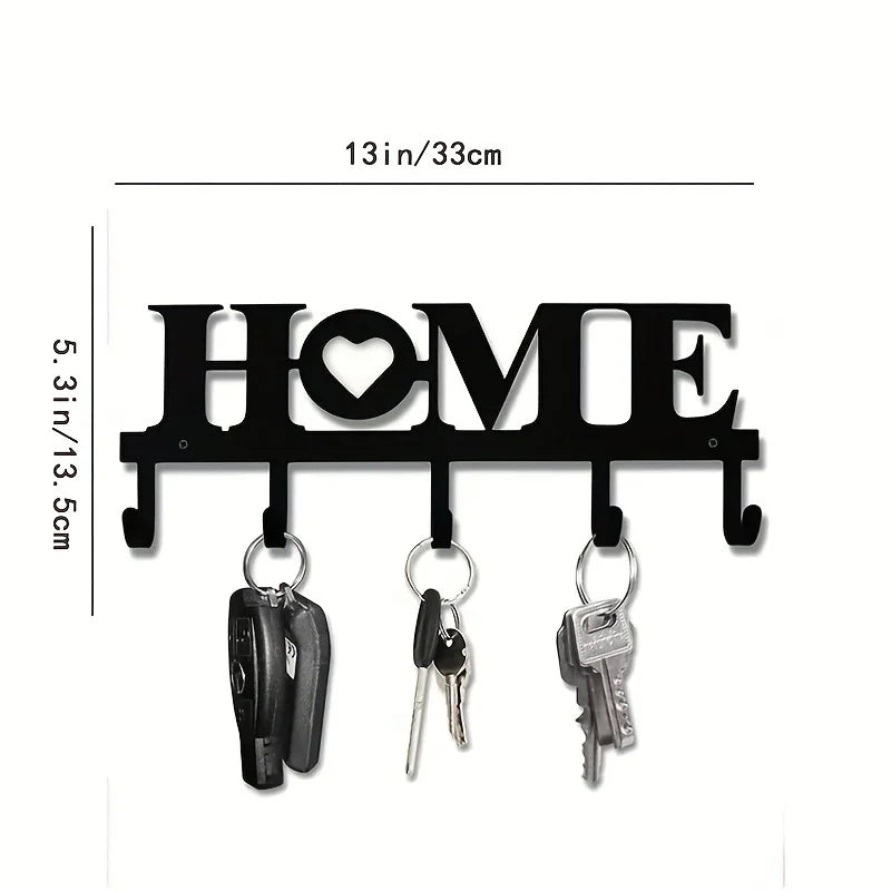 Black rustic iron key holder wall art with a heart cutout displaying the word HOME