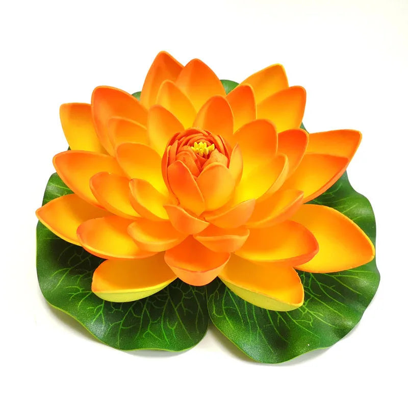 An artificial orange lotus flower with green leaves used for pond and garden decor.