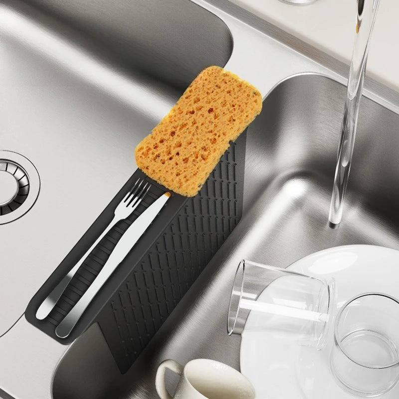 A non-slip silicone kitchen sink protector mat with drainage is shown in a stainless steel sink.