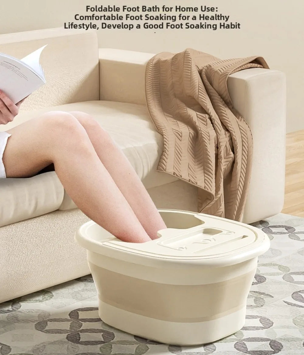 A beige portable foldable foot bath tub is shown next to a sofa, with a person's legs soaking in the bath.