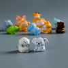 A collection of mini resin cartoon animal figurines in various colors including orange, yellow, blue, and brown.