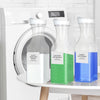 Three refillable glass bottles of laundry detergent with white and green contents sitting on a white shelf.