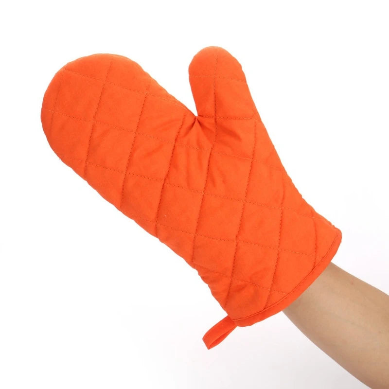 An orange quilted heat resistant oven mitt being worn on a hand.